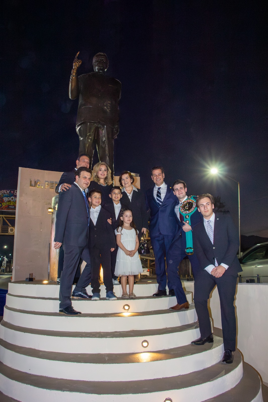 Fotografía familiar frente a un monumento durante un encuentro nocturno